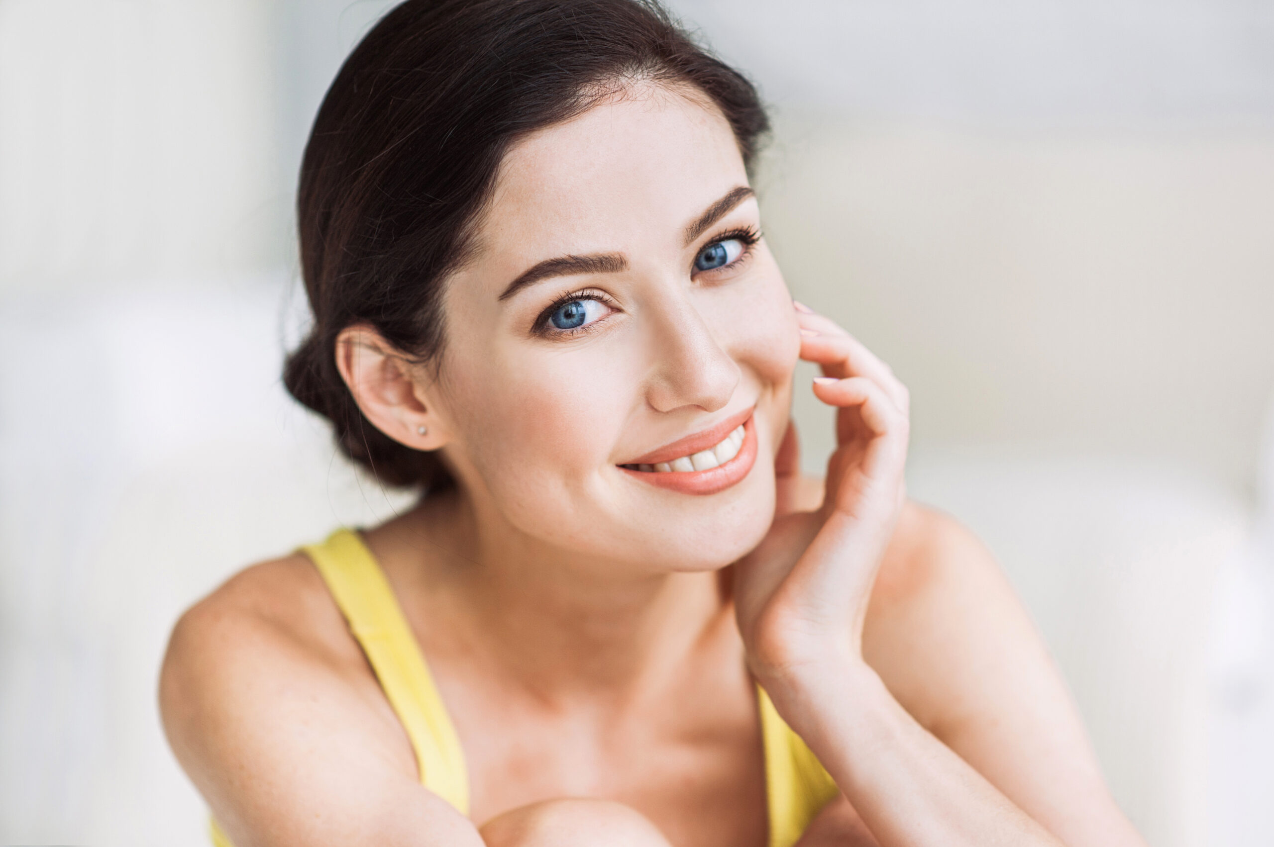Beautiful young woman portrait. Smiling girl looking at camera and enjoying life at home. Beauty, relaxation, wellbeing, mindfulness concept
