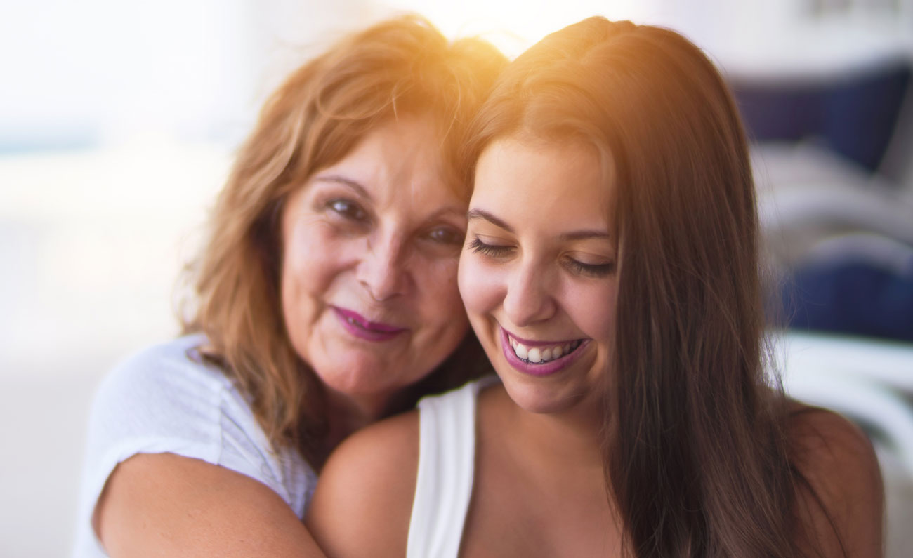 Beautiful mother and daugther hugging at terrace with happy face