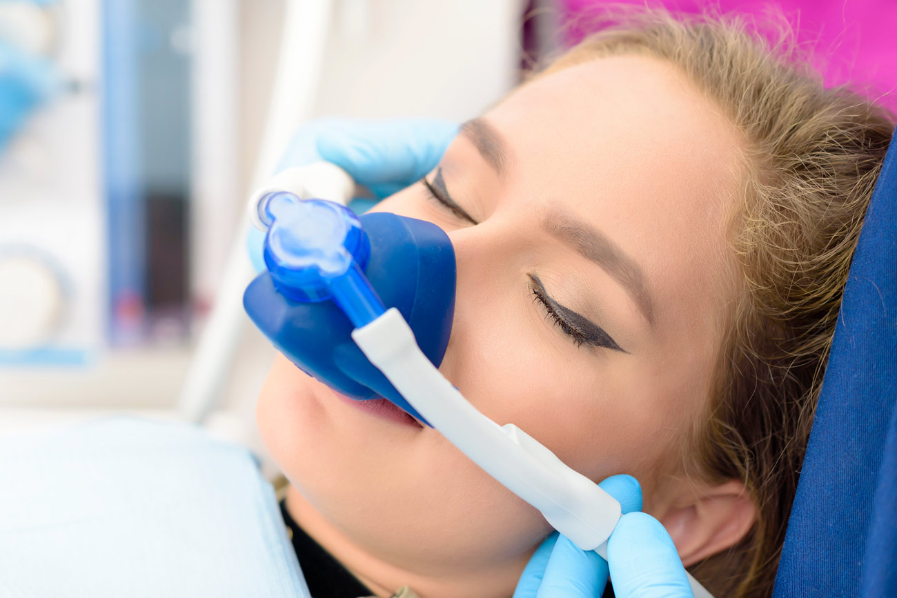 Woman with blue nitrous mask on his nose